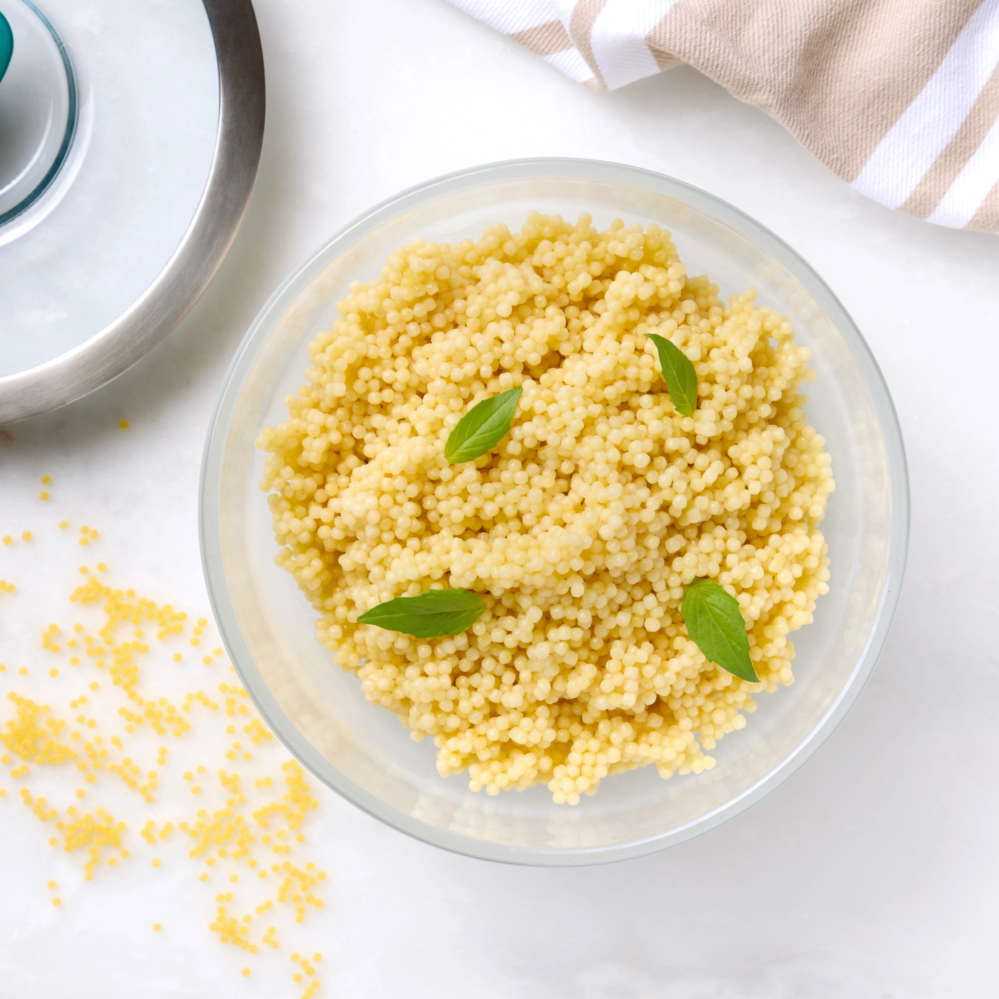 Cooked pastina in a clear Anyday dish, with spoon resting inside and lid nearby