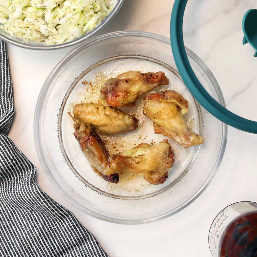 Microwave chicken wings with salt and pepper in an Anyday glass dish, with sauce and fresh salad on the side