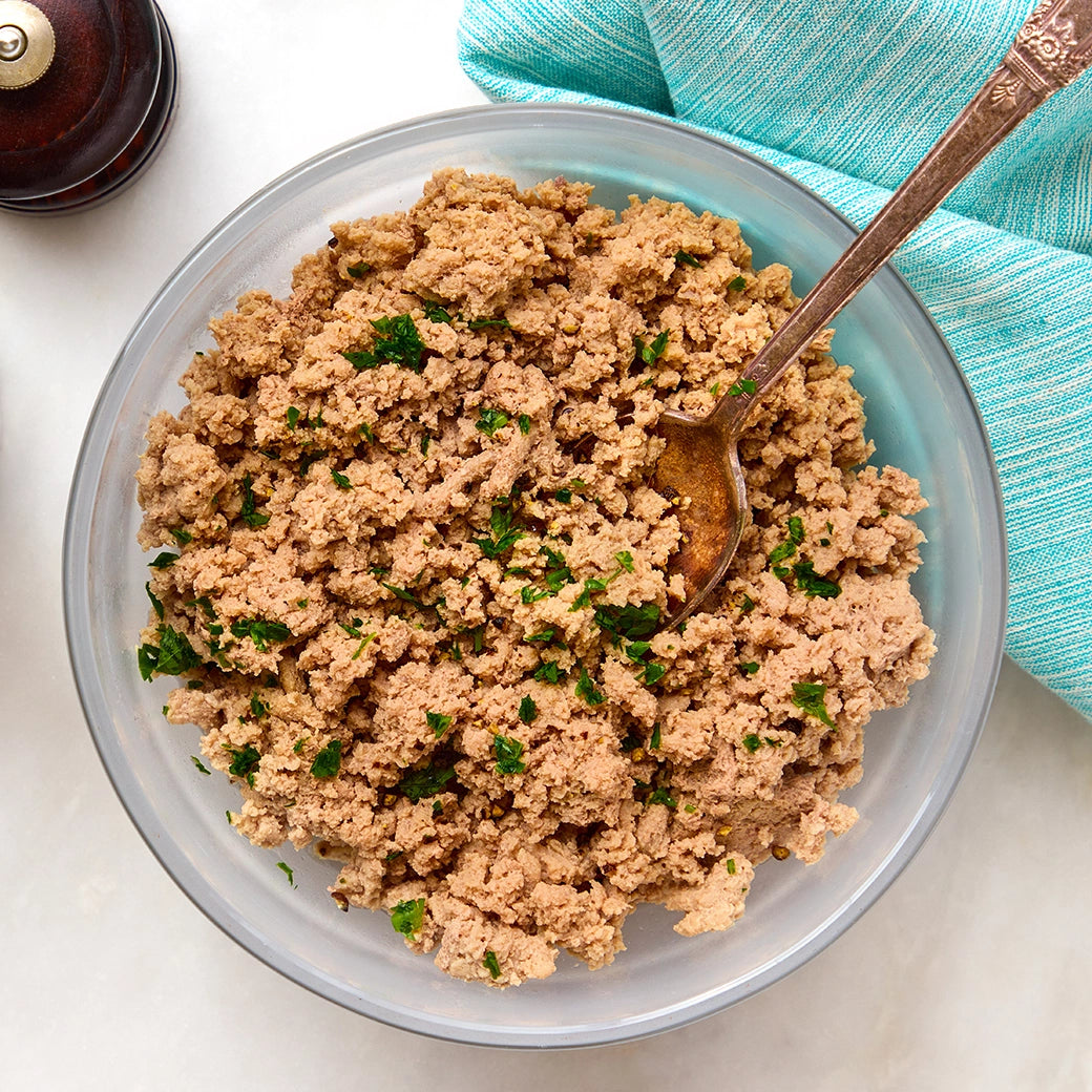Cooked ground turkey crumbles in a clear Anyday dish with a spoon nearby