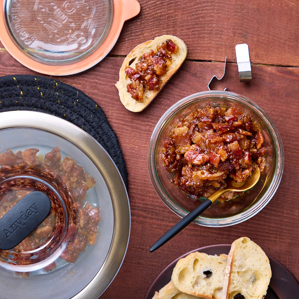 Bacon and onion jam served in a clear glass Anyday dish, paired with slices of crusty bread for spreading.