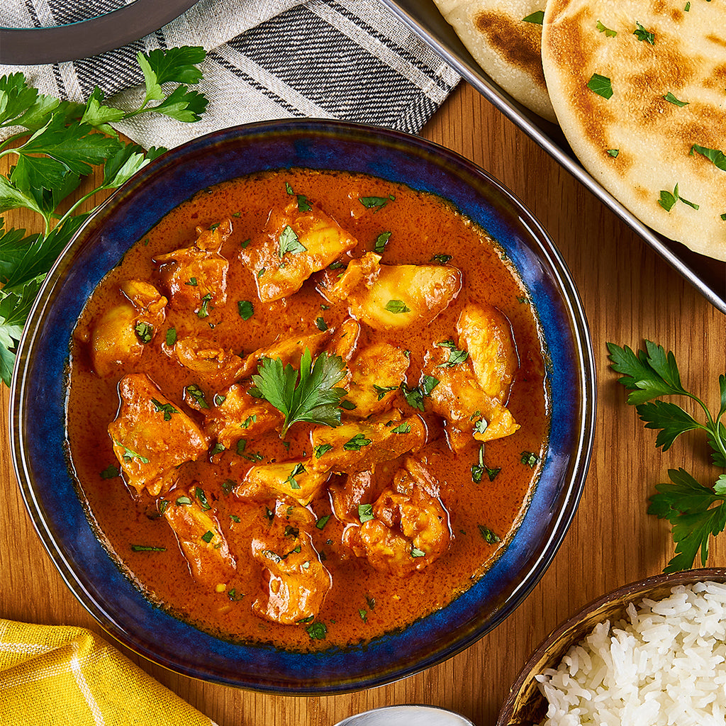 Butter Chicken Curry made and served in the glass Anyday dish, featuring tender chicken in a creamy tomato sauce, garnished with cilantro, and accompanied by basmati rice