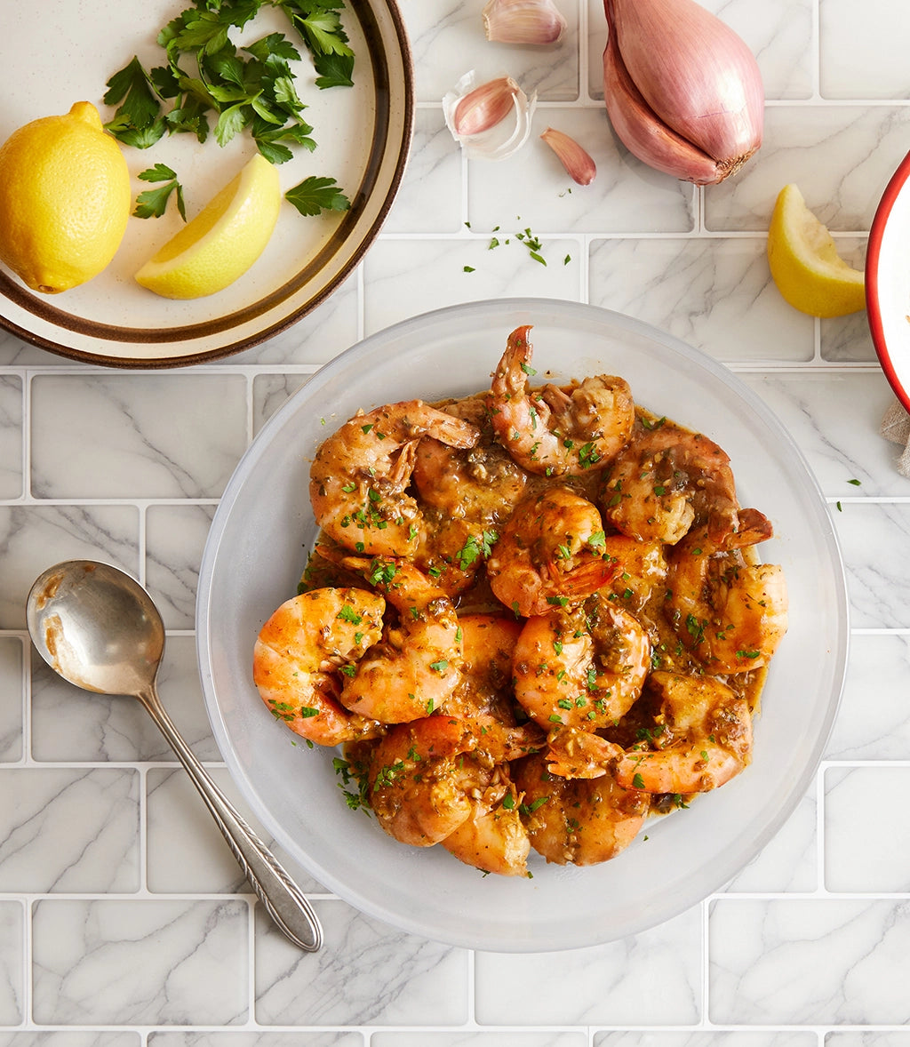 Buttery New Orleans BBQ Shrimp made and served in the glass Anyday dish, featuring succulent shrimp in a rich, buttery BBQ sauce.