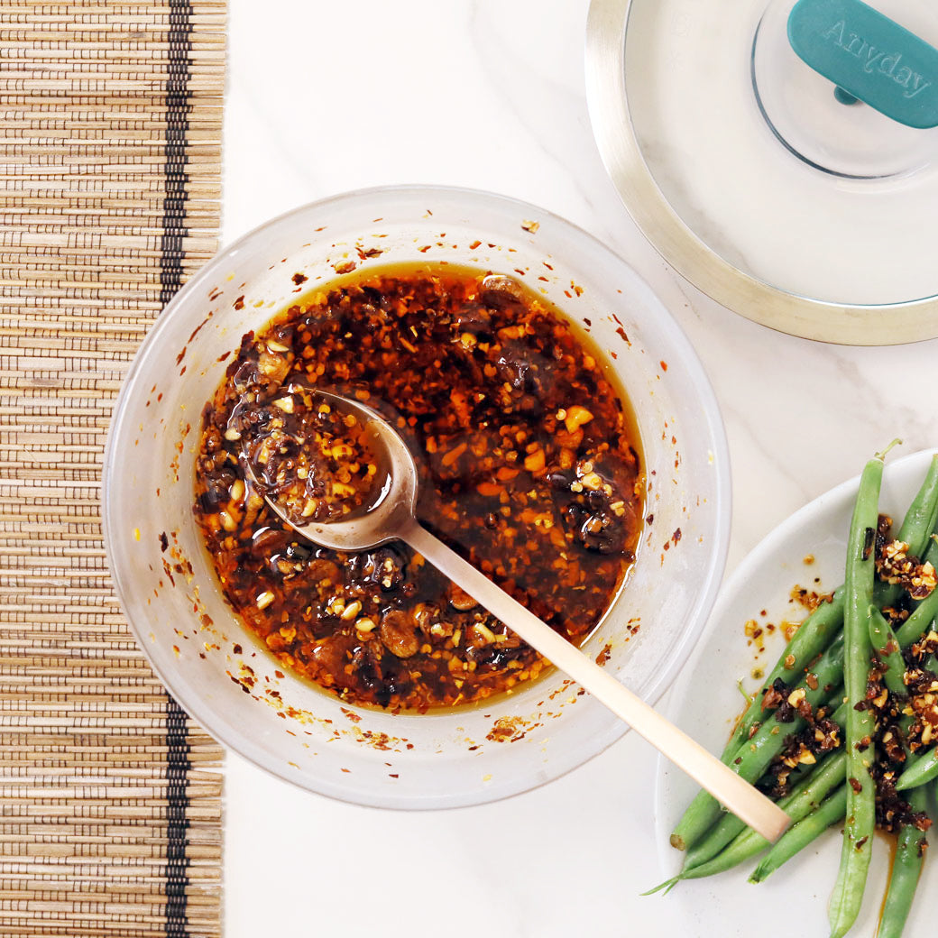 A jar of homemade chili crisp with crispy garlic and shallots, made in the microwave for a quick, flavorful topping.