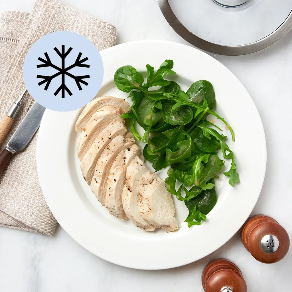 Frozen chicken breast placed in a glass Anyday dish on a plain surface