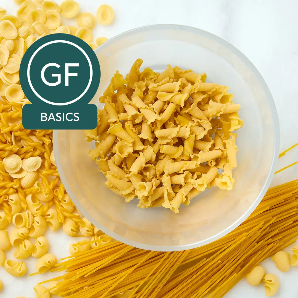 Cooked gluten-free pasta in a clear Anyday dish with a spoon and light steam visible