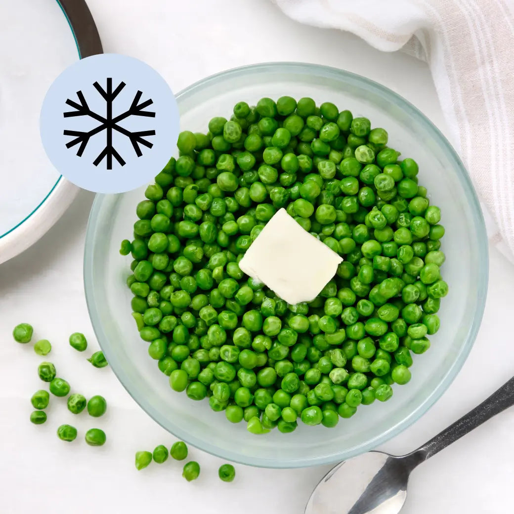 Bright green frozen peas in a clear Anyday dish with visible steam and lid off