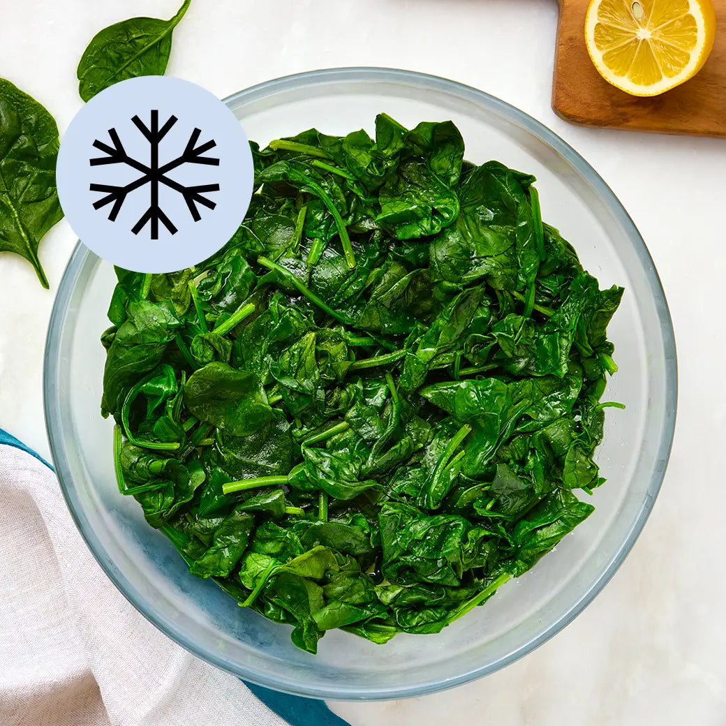 Frozen spinach clumps in a clear Anyday dish on a clean, neutral surface