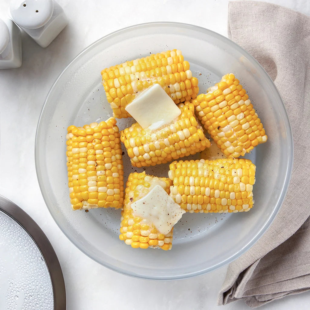 Microwave corn on the cob with pats of butter in an Anyday Large Shallow dish