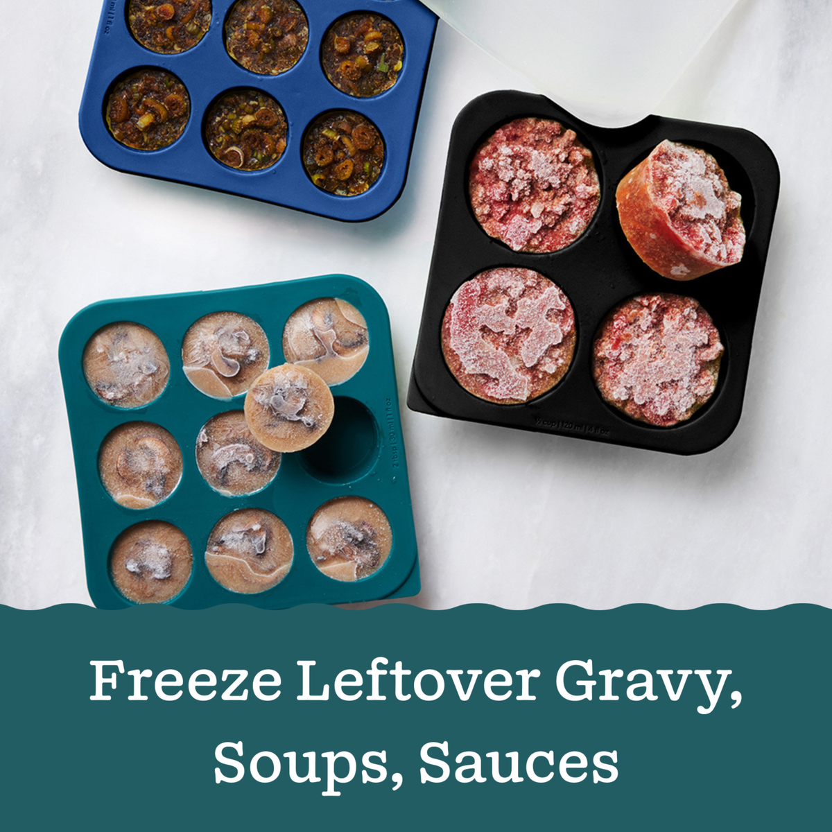 Three square silicone food freezing trays from The Starter Gift Bundle in blue, teal, and black, each filled with portions of gravy, soups, and sauces, with text below reading: Freeze Leftover Gravy, Soups, Sauces.
