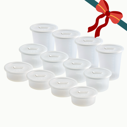 The Anydeli Lovers Bundle includes eleven translucent Mochi-colored nesting silicone food storage containers with matching covers arranged in a group with a decorative red bow graphic in the corner.