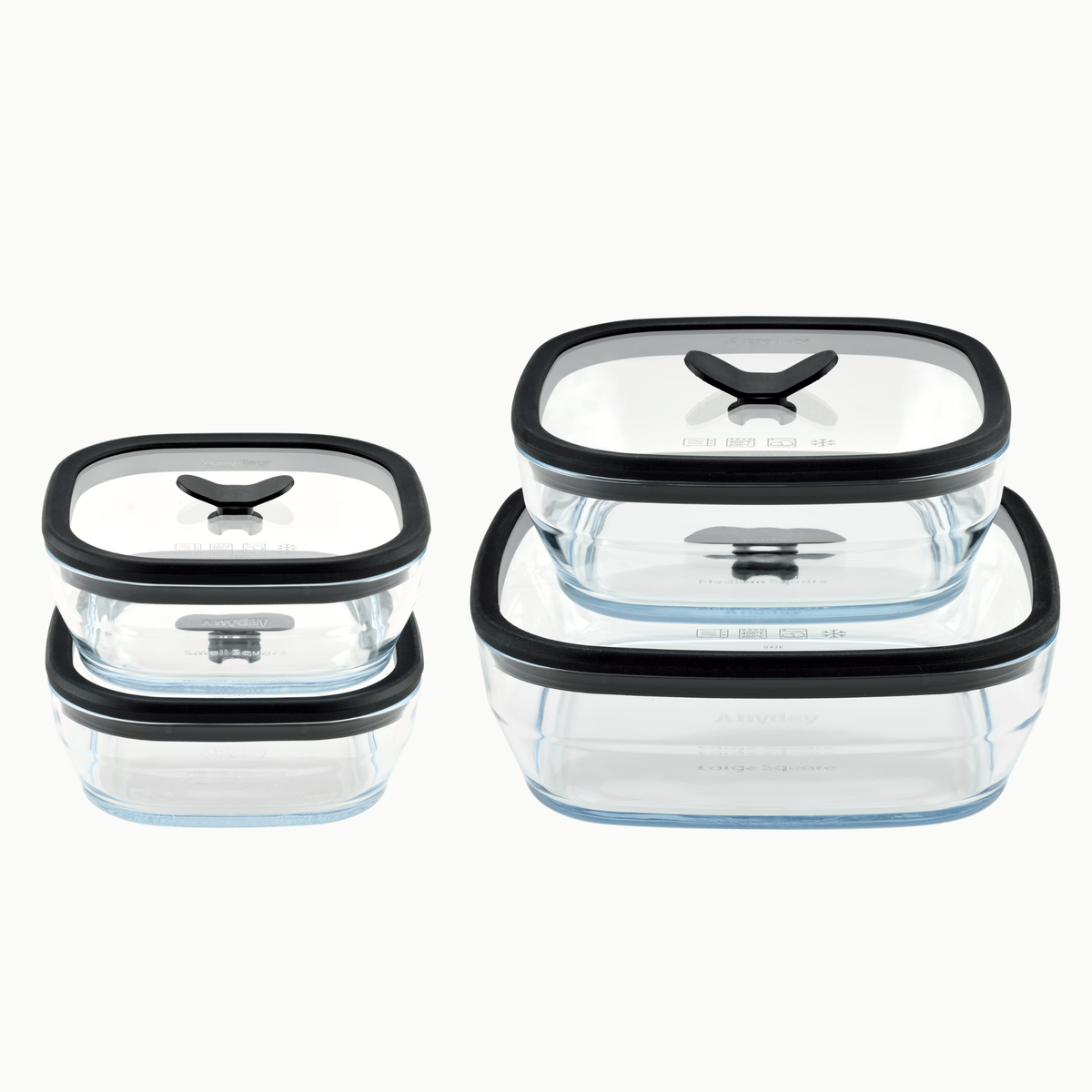 Four square, frosted glass food storage containers from the Anyday 8-Piece Glass Square Dish Set in Black Sesame, featuring black glass lids with black silicone steam vents in varying sizes.