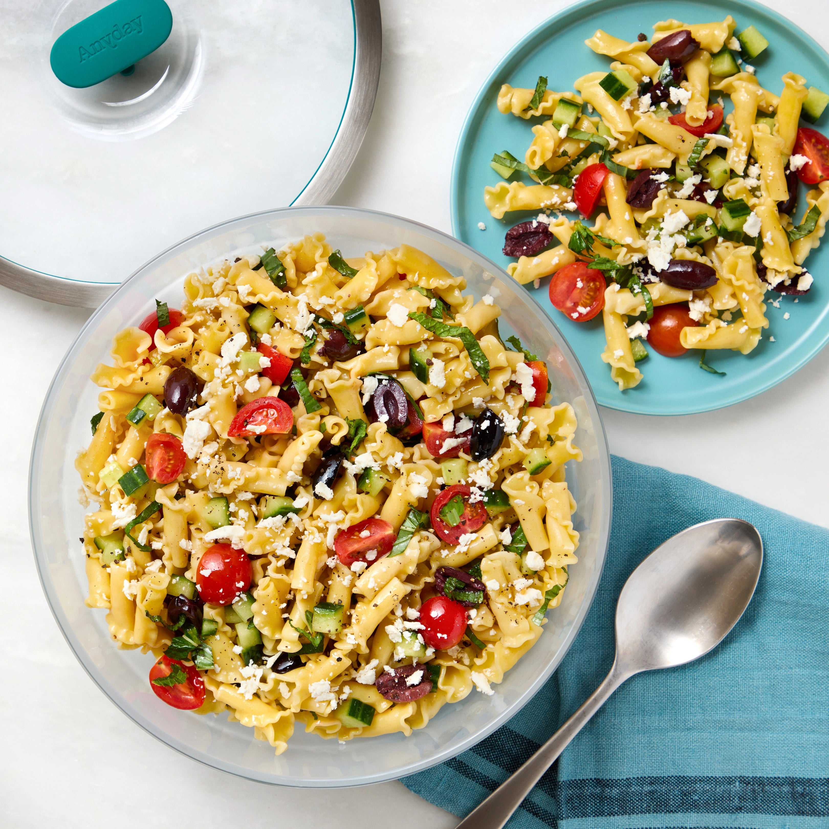 Flavorful Mediterranean Pasta Salad made in the glass Anyday dish, consisting of penne pasta, cucumbers, cherry tomatoes, black olives, and feta cheese. This method ensures perfectly cooked pasta without the need to pre-boil water, ideal for a refreshing and vibrant side dish.