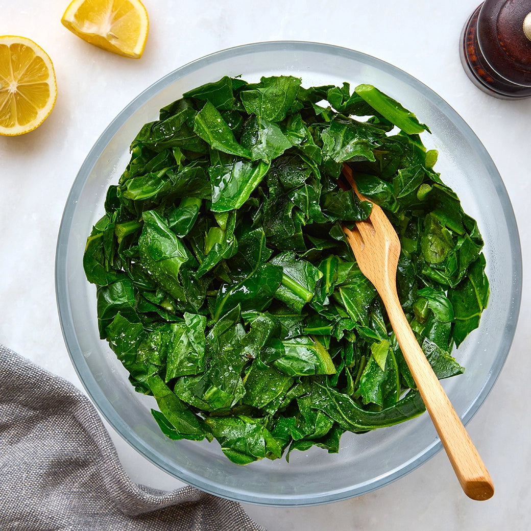 Perfectly cooked collard greens made and served in the glass Anyday dish, providing tender  but not overcooked and flavorful greens. This method ensures evenly cooked collard greens, ideal for a nutritious side dish or adding to various recipes.