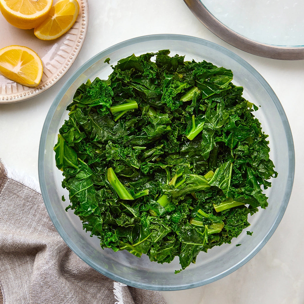 Perfectly cooked kale made and served in the glass Anyday dish, providing tender and flavorful greens. This method ensures evenly cooked kale, ideal for a nutritious side dish or adding to various recipes.