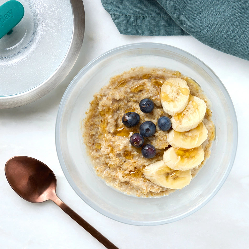 A bowl of creamy, microwave-cooked oatmeal in an Anyday dish, topped with fruit and nuts.