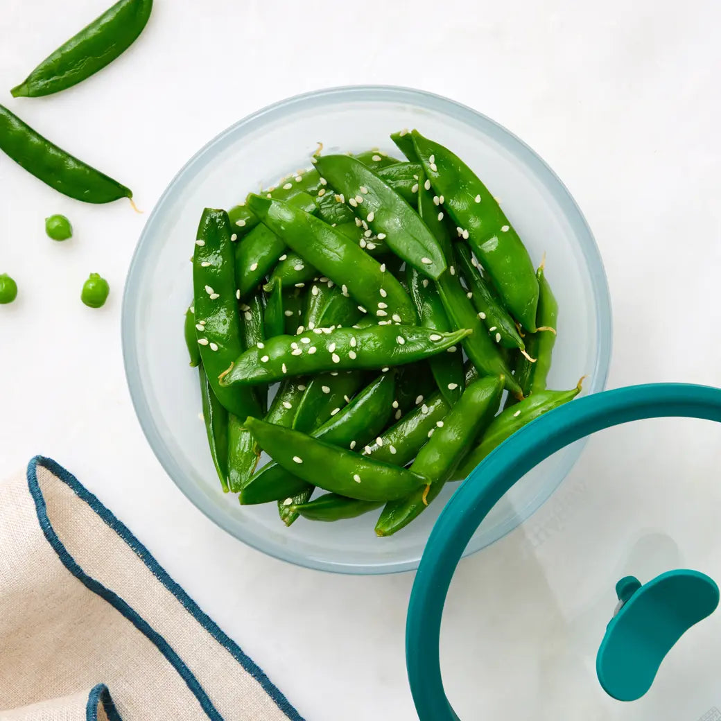 Perfectly cooked sugar snap peas made and served in the glass Anyday dish, providing tender and crisp peas. This method ensures evenly cooked sugar snap peas, ideal for a nutritious and tasty side dish or snack.