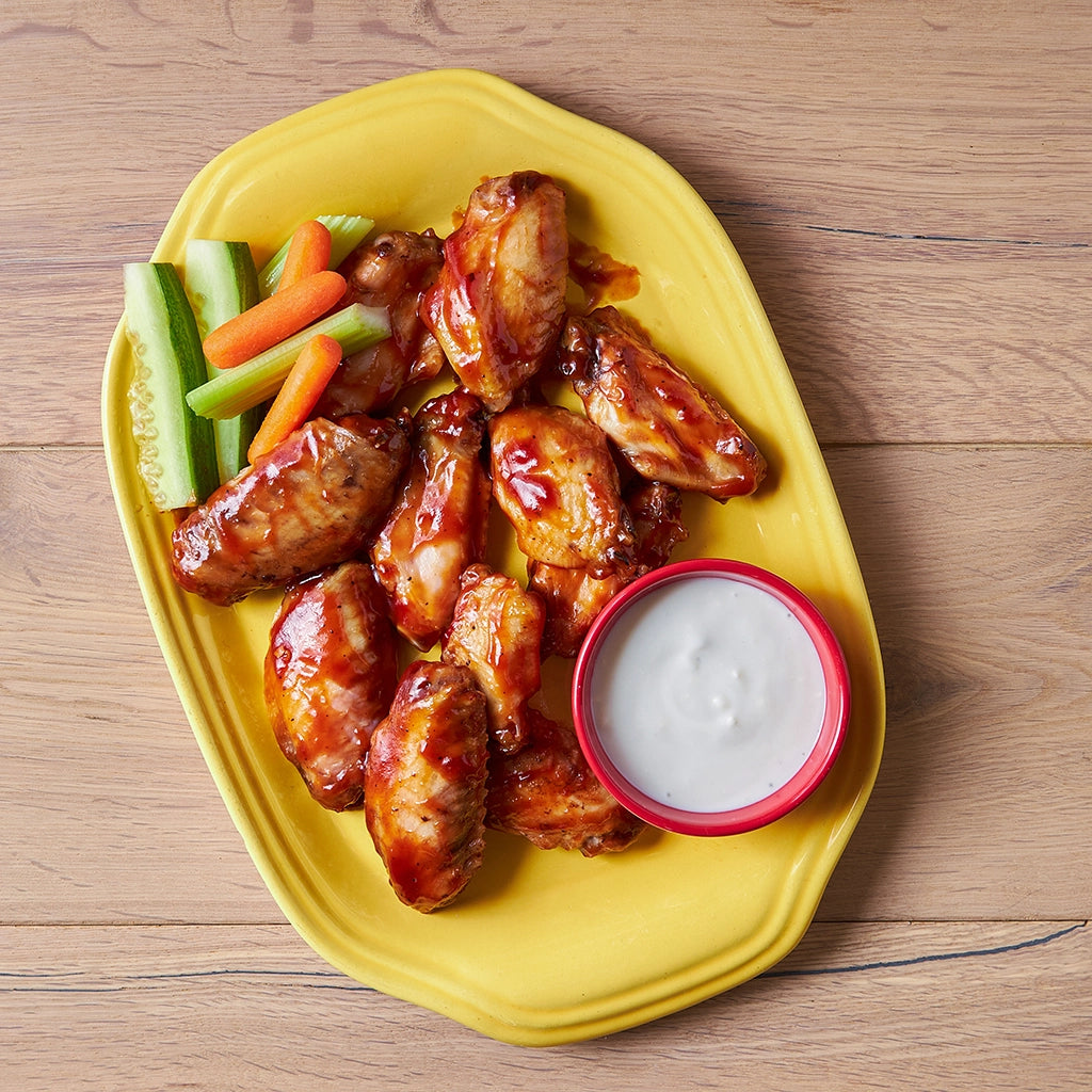 BBQ wings made in a glass Anyday dish and served with a side of ranch dressing, celery sticks, and baby carrots, prepared in an Anyday dish.