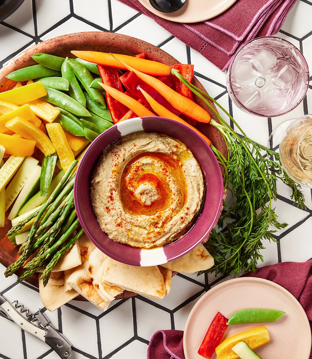 Baba ganoush served in a clear glass Anyday dish, accompanied by colorful fresh vegetables and pita bread for dipping.