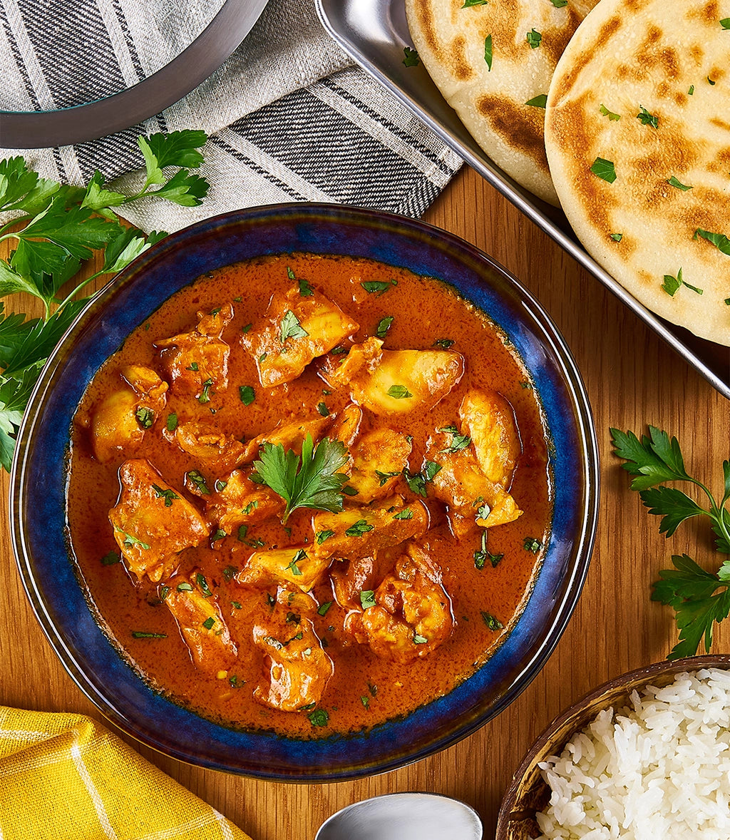 Butter Chicken Curry made and served in the glass Anyday dish, featuring tender chicken in a creamy tomato sauce, garnished with cilantro, and accompanied by basmati rice