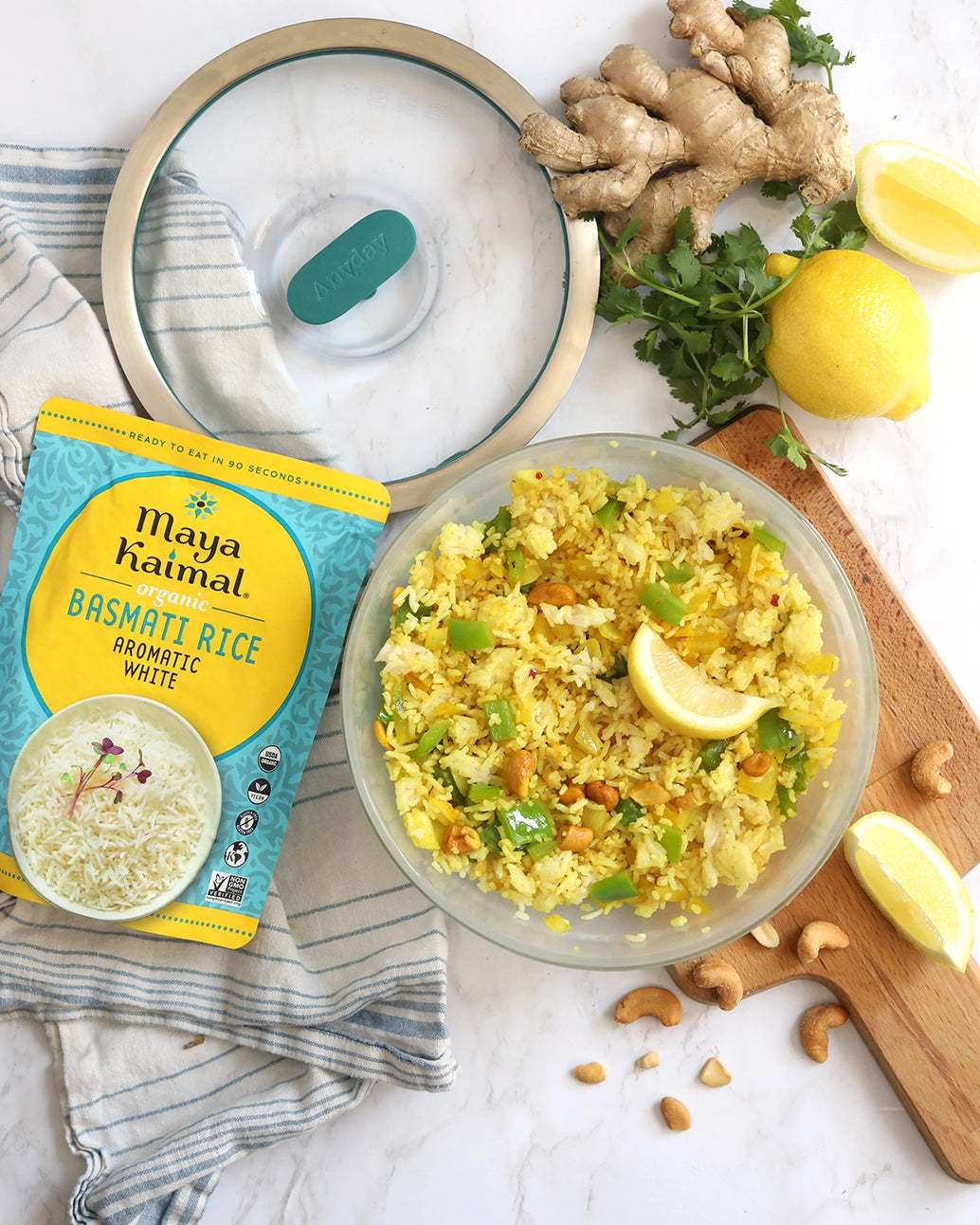 Easily cooked Maya Kaimal's Spiced Lemon Rice made in the glass Anyday dish, consisting of fragrant basmati rice with mustard seeds, cashews, ginger, and turmeric. This method ensures flavorful and aromatic rice, perfect for a delightful side dish.