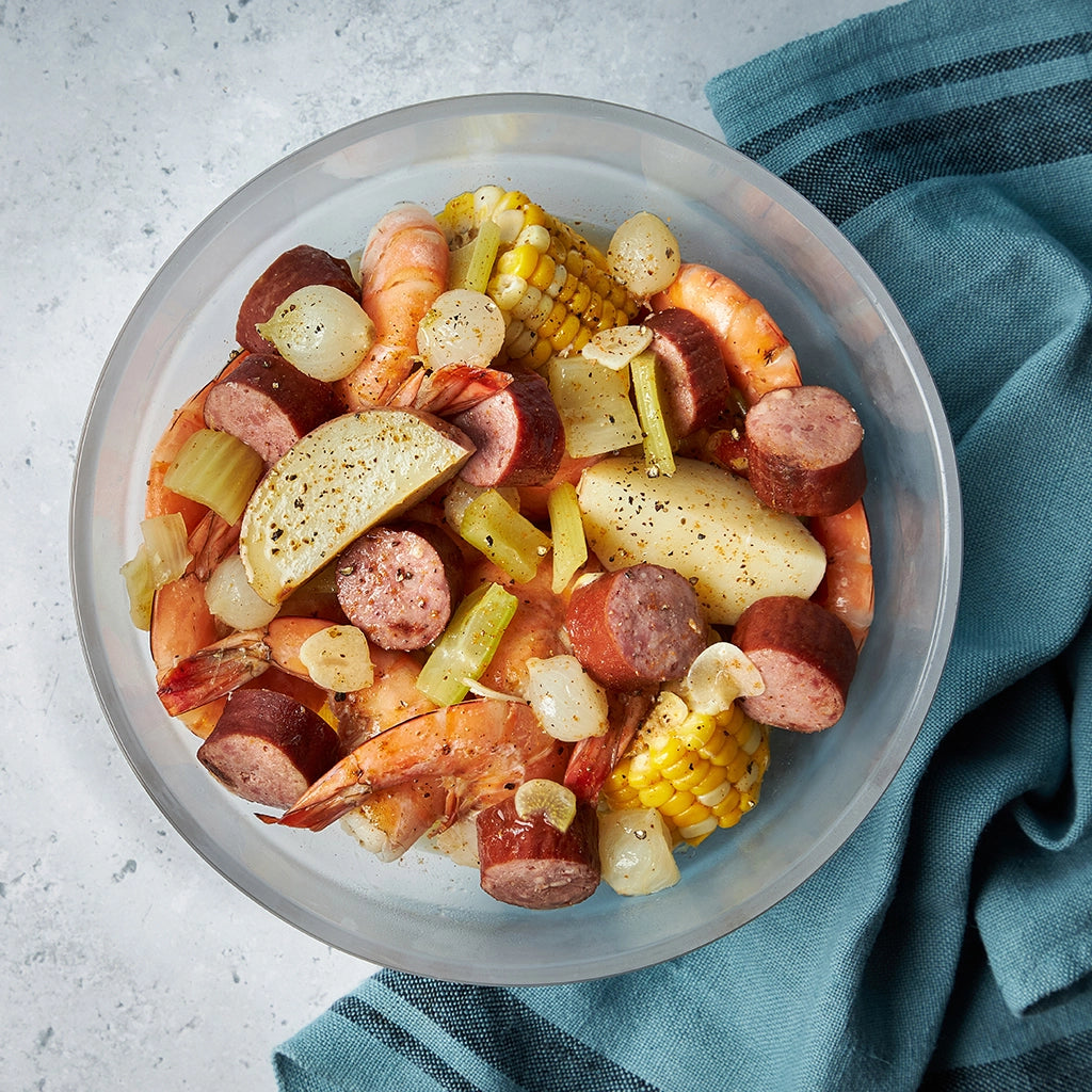 Flavorful Cajun shrimp boil made in the glass Anyday dish, which consists of succulent shrimp, corn, potatoes, and sausage seasoned with zesty Cajun spices. This quick and easy microwave recipe delivers a delicious and hearty meal, perfect for a satisfying dinner.