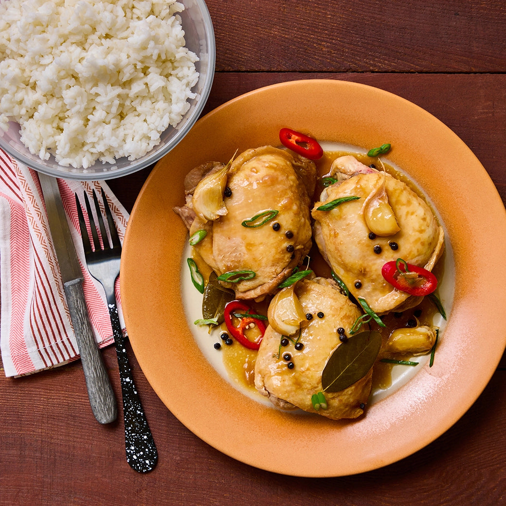 Chicken Adobo made and served in the glass Anyday dish, featuring tender chicken cooked in a savory soy-vinegar sauce with garlic and bay leaves.