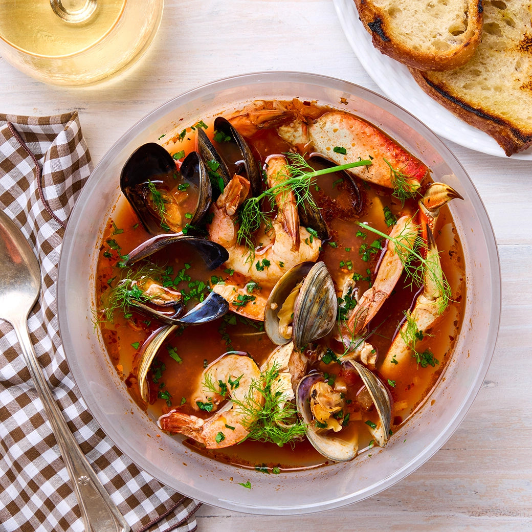 Cioppino made and served in the glass Anyday dish, featuring a flavorful seafood stew with tomatoes, herbs, and spices.