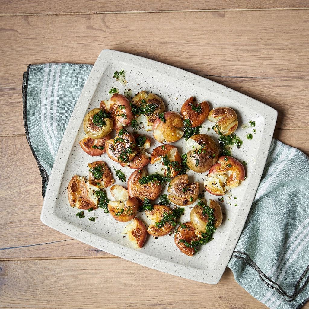 Crispy Smashed Potatoes made and served in the glass Anyday dish, featuring golden brown potatoes finished in a hot pan with a crispy exterior and tender interior, seasoned with herbs.