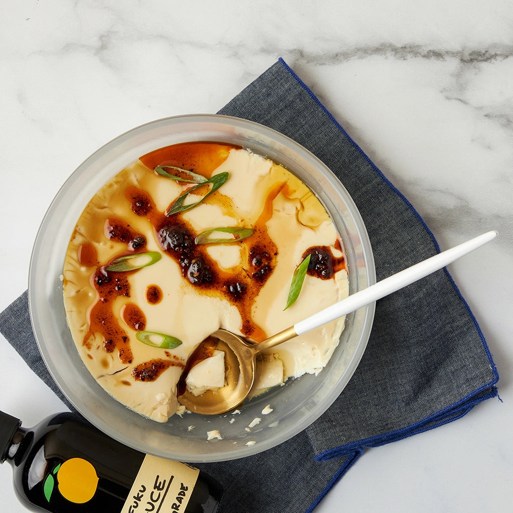 Dave Chang's Chawanmushi made and served in the glass Anyday dish, featuring a delicate Japanese egg custard with savory ingredients like dashi, soy sauce, and garnished with green onions.