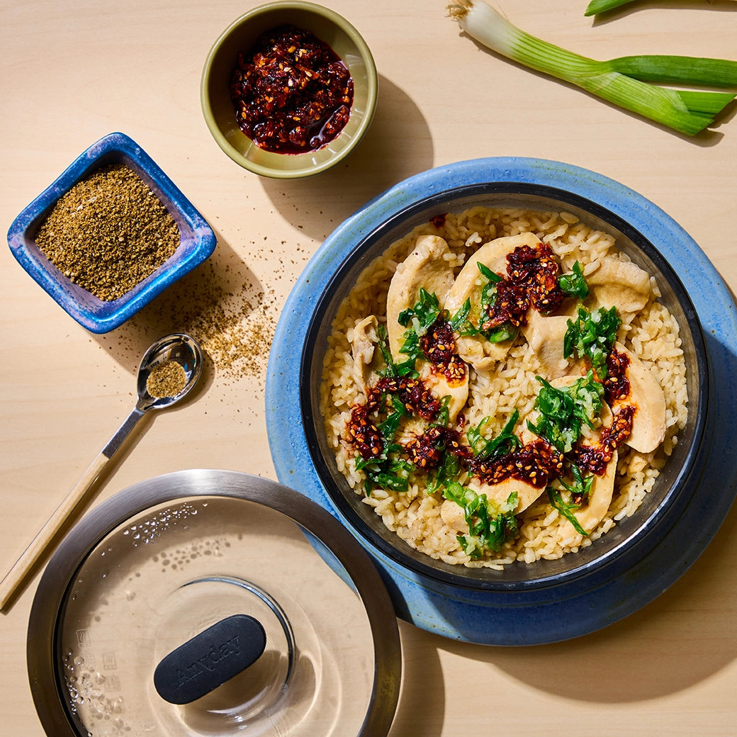 David Chang's Hainanese Chicken made and served in the glass Anyday dish, featuring tender poached chicken alongside fragrant rice and a flavorful ginger scallion sauce.