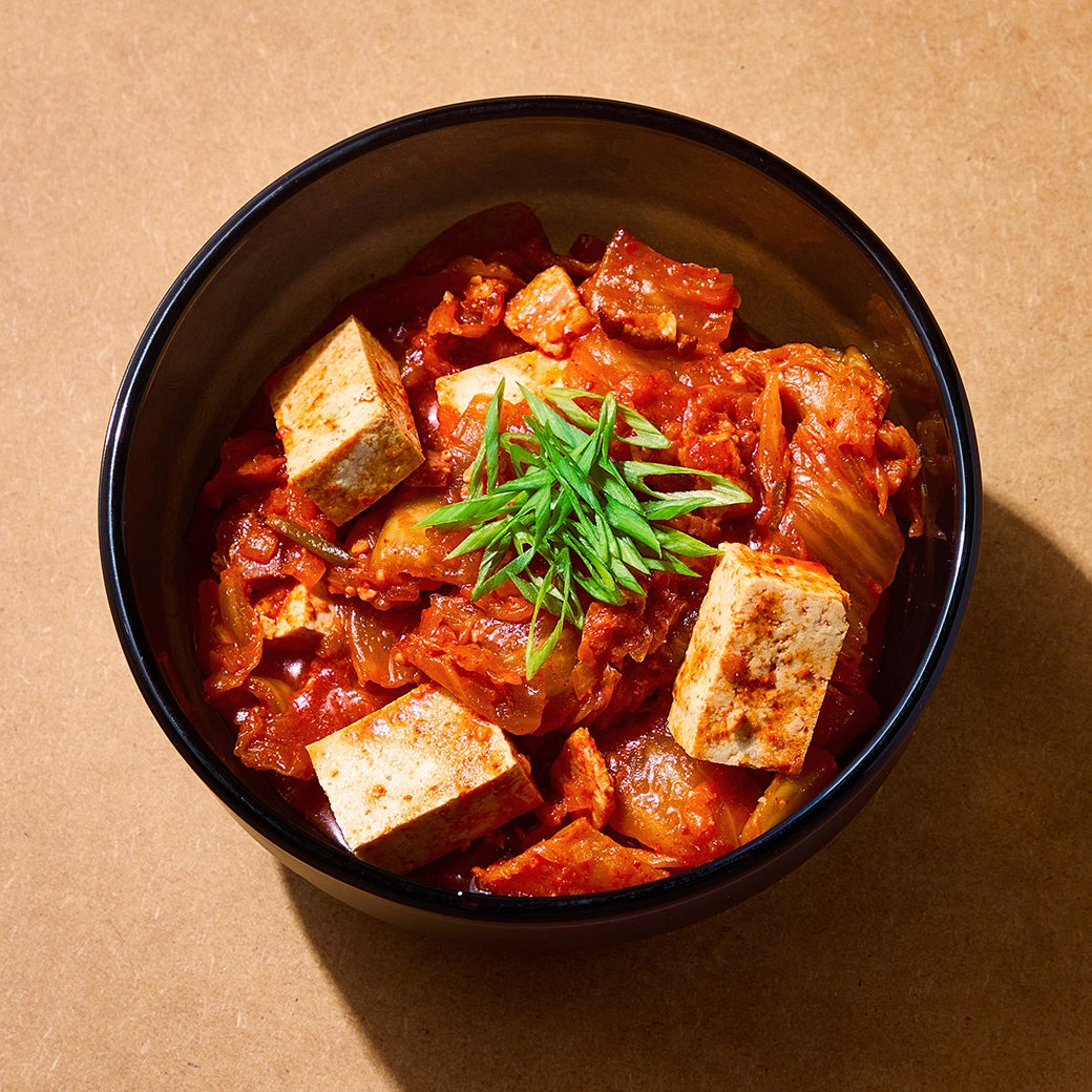 David Chang's Easy Kimchi Jjigae made and served in the glass Anyday dish, featuring a spicy and savory Korean stew with kimchi, tofu, and vegetables.