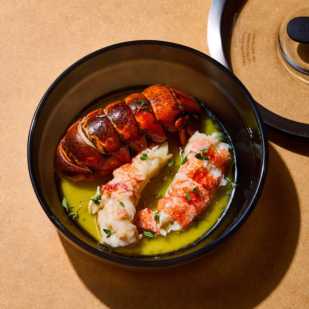 David Chang's Butter Poached Lobster made and served in the glass Anyday dish, featuring succulent lobster in a buttery sauce, garnished with fresh herbs.