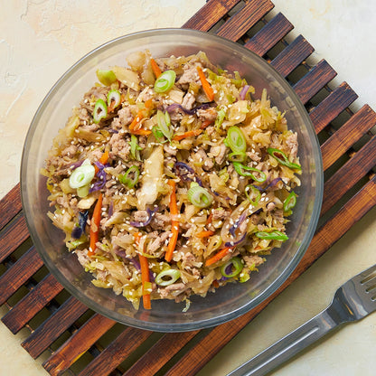 Egg Roll in a Bowl made and served in the glass Anyday dish, featuring seasoned ground meat, shredded cabbage, and carrots, topped with green onions.
