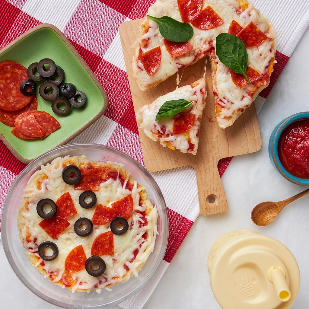 DIY Kid Pizzas made and served in the glass Anyday dish, featuring mini pizza bases with a variety of toppings for kids to create their own personalized pizzas.