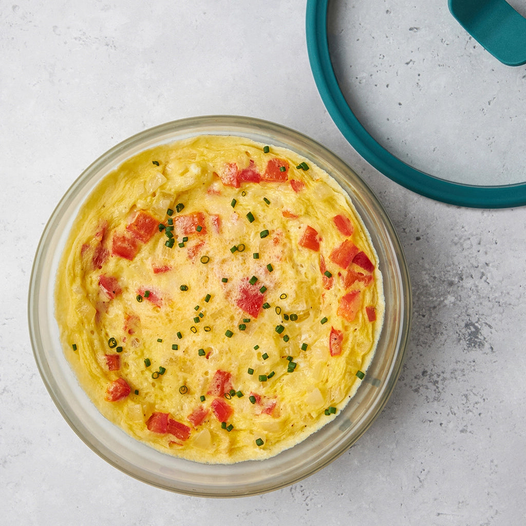 Frittata with peppers and fresh herbs made and served in the glass Anyday dish, featuring a fluffy egg base filled with vegetables and cheese, cooked to perfection.