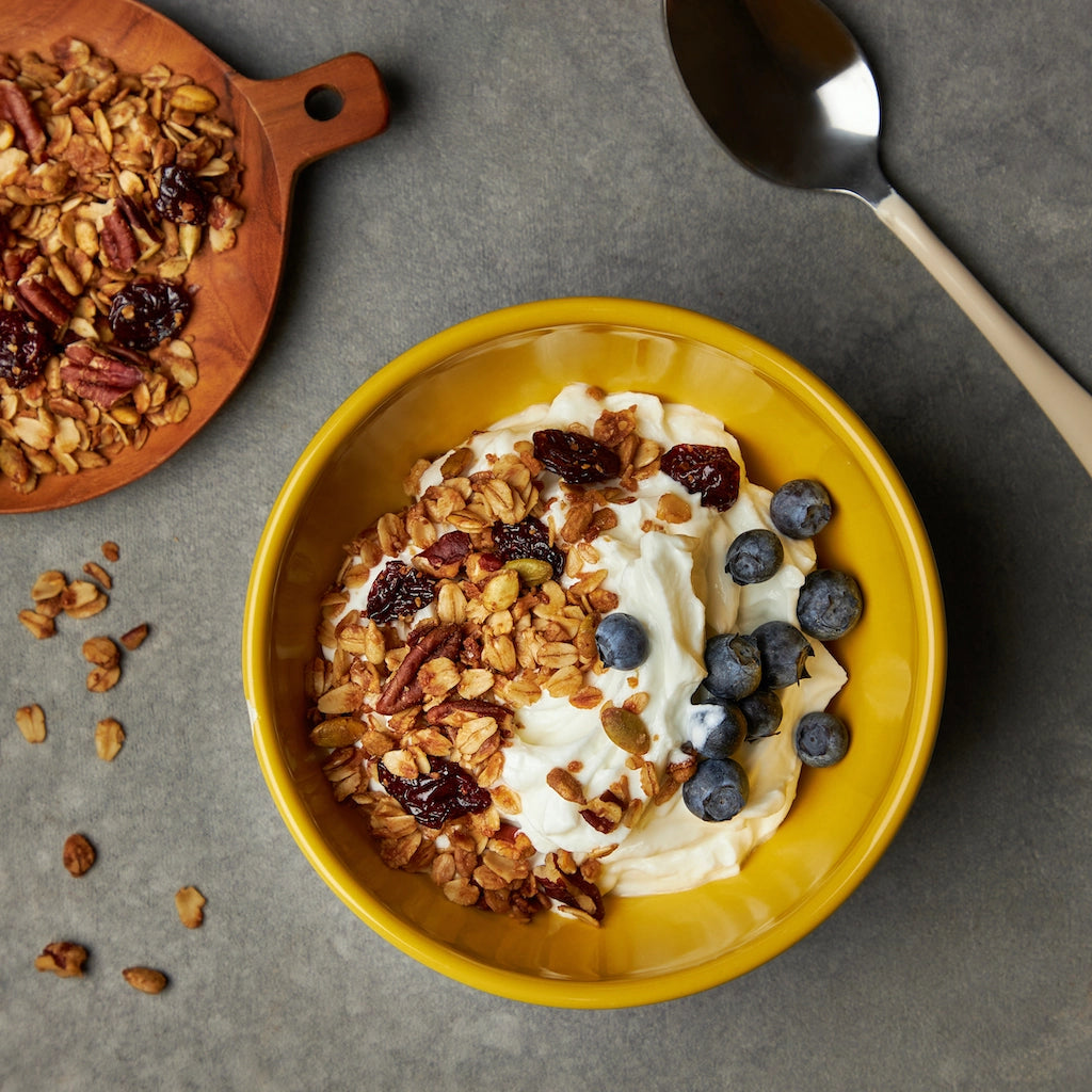 Granola made in the glass Anyday dish, featuring a crunchy low sugar mix of oats, nuts, seeds, and dried fruits, perfect for a nutritious breakfast or snack.