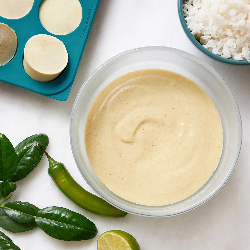 Green Curry Sauce made and served in the glass Anyday dish, featuring a vibrant, spicy blend of Thai style green curry paste, coconut milk, and fresh herbs.