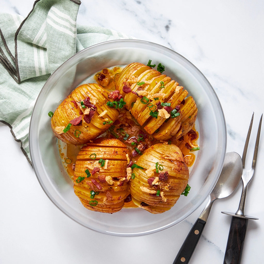 Quick and easy Hasselback Potatoes made and served in the glass Anyday dish, featuring thinly sliced Yukon potatoes with olive oil, thyme, and paprika. This method ensures tender and flavorful potatoes, ideal for a delicious and customizable side dish.