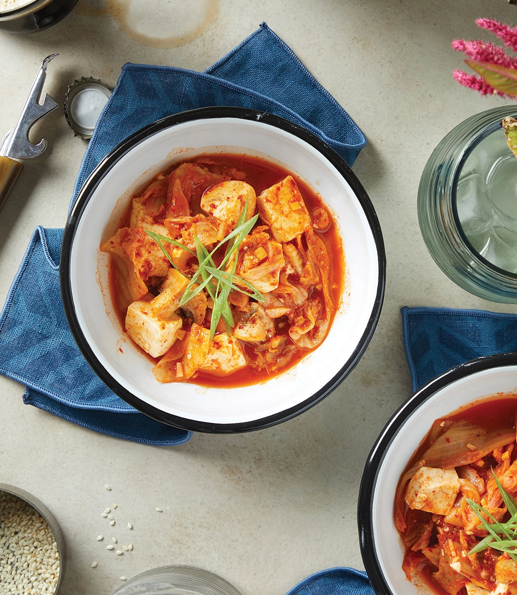 Perfectly cooked Kimchi Tofu and Mushroom Stew made and served in the glass Anyday dish, providing a flavorful and hearty stew. This method ensures tender tofu and mushrooms with a rich, umami-packed broth, ideal for a comforting meal.