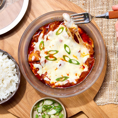 Perfectly cooked Korean Cheese Buldak made and served in the glass Anyday dish, featuring spicy chicken in a rich gochujang sauce topped with melted cheese. This method ensures tender chicken and melted cheese, ideal for a flavorful and comforting meal.