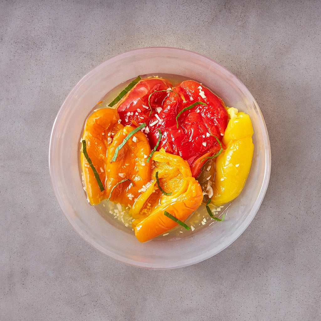 Easy marinated peppers made in the glass Anyday dish, consisting of sweet bell peppers marinated with garlic, olive oil, and fresh basil. This method ensures tender and flavorful peppers, perfect for a quick and delicious side or topping