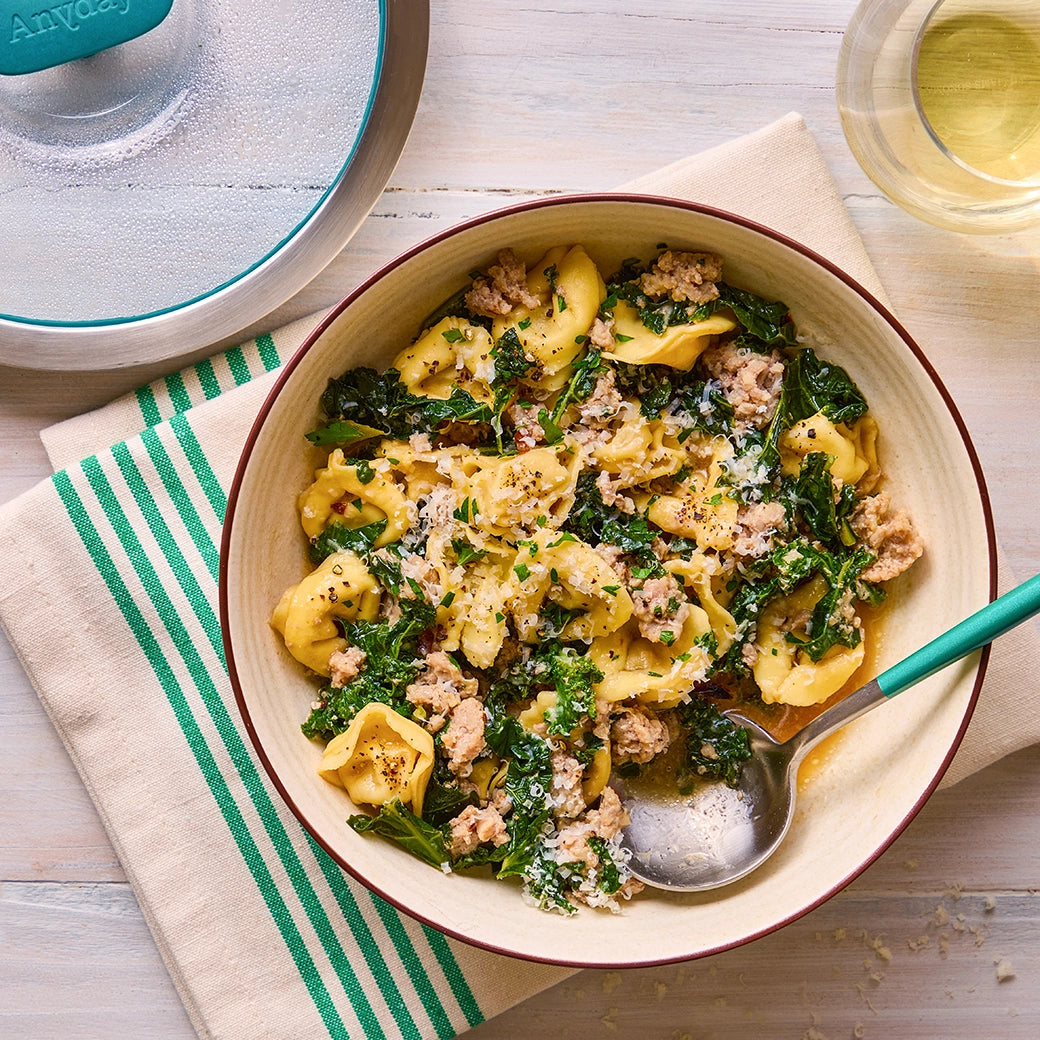 Effortlessly cooked sausage and kale tortellini made in the microwave with the glass Anyday dish, capturing all the savory flavors and nutrients without the need to pre-boil the water. Perfect for a quick and hearty meal that's full of flavor.