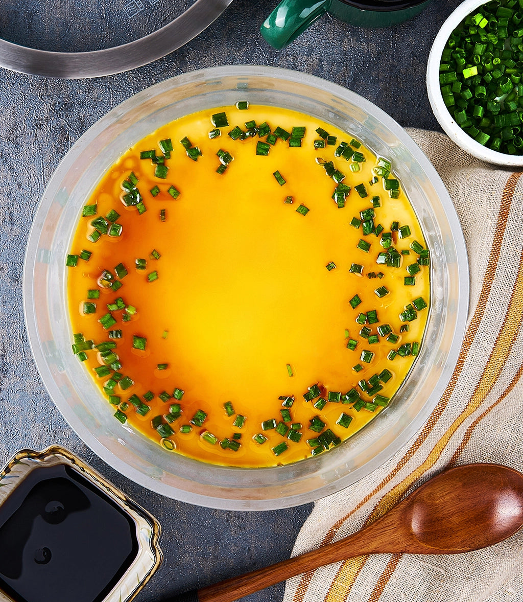 Chinese Steamed Egg Custard made and served in the glass Anyday dish, featuring a smooth and silky egg custard garnished with green onions.