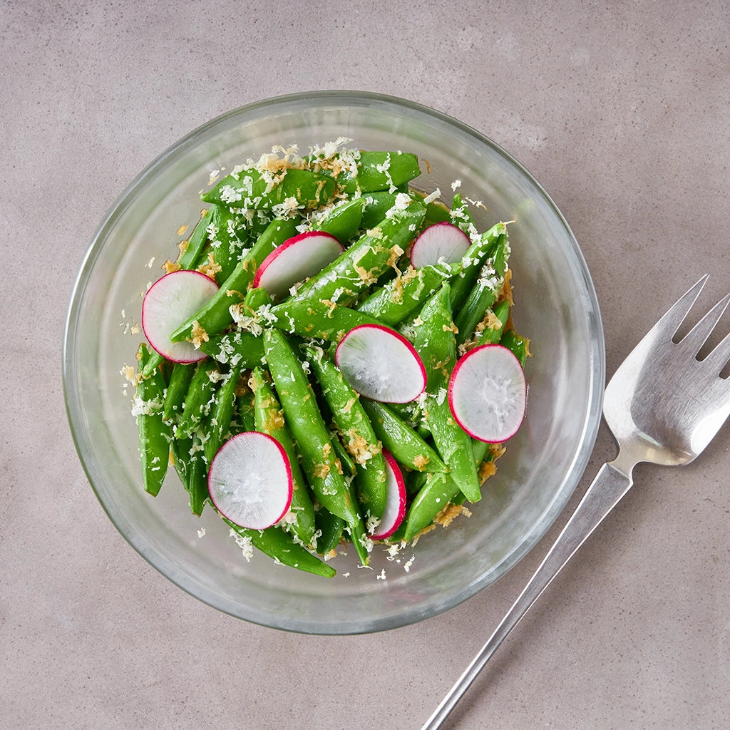 Crisp and tender sugar snap peas, prepared by Chef David Chang, cooked in the microwave using the glass Anyday dish, retaining their fresh flavor and vibrant color. Enjoy a quick and healthy side dish, ready in minutes.