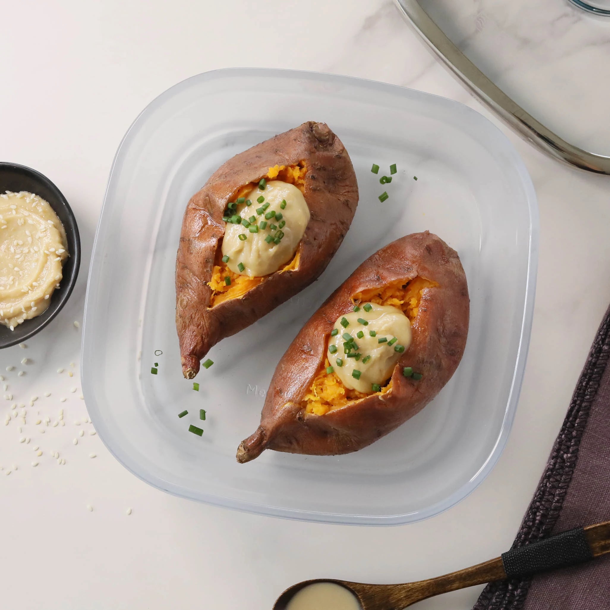 Tender sweet potatoes with miso tahini butter cooked in the microwave using the glass Anyday dish, offering a rich, savory-sweet flavor combination. Enjoy a quick and satisfying side dish, ready in minutes.