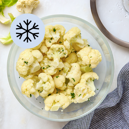 Frozen cauliflower florets in a clear Anyday dish with a spoon and lid nearby


