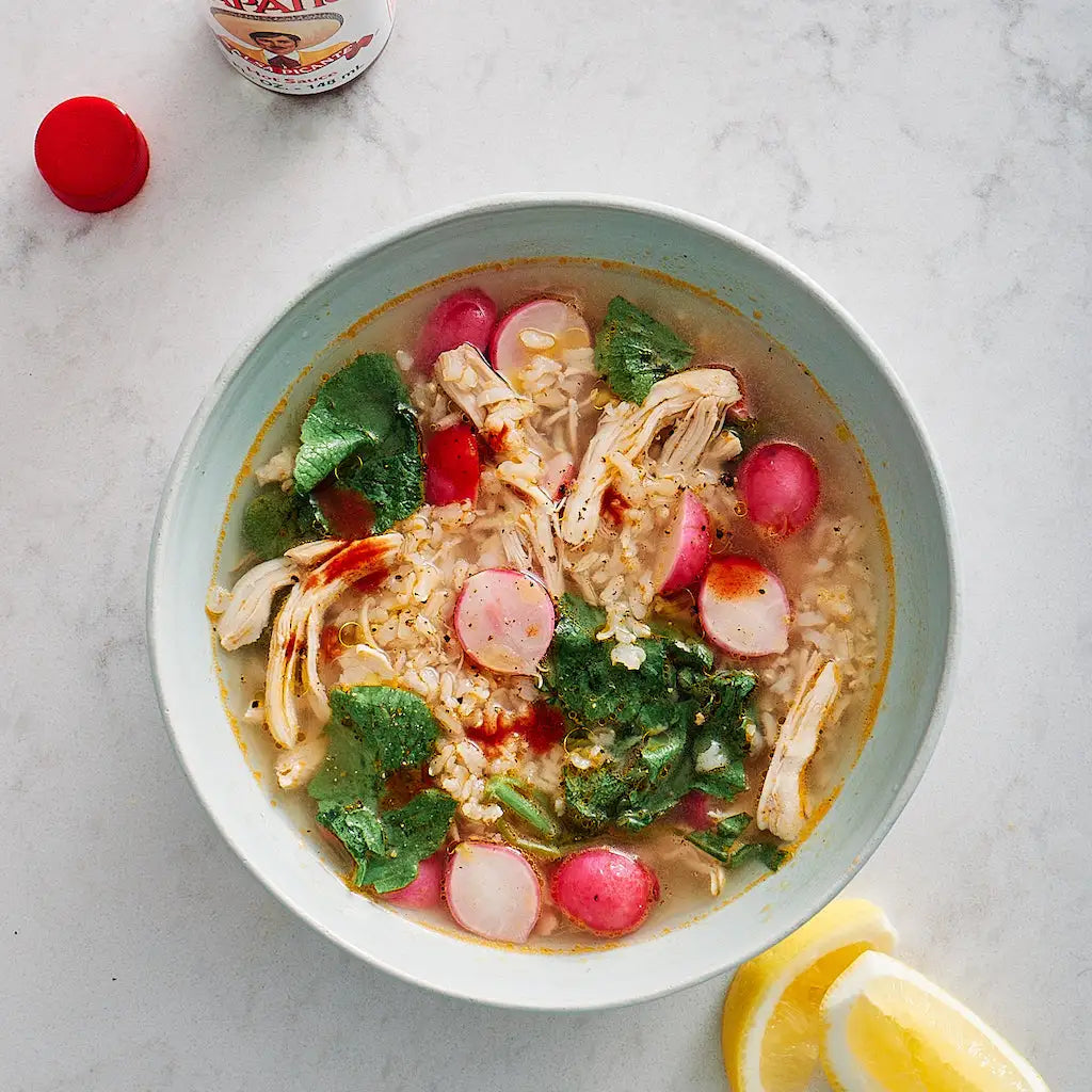 Joshua McFadden's nutritious Chicken Soup with Brown Rice, Radishes, and Lemon, cooked and served in the glass Anyday dish. This hearty recipe features tender chicken, wholesome brown rice, and zesty lemon, perfect for a comforting meal.