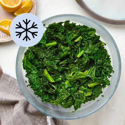 Chopped frozen kale in a glass Anyday dish, lightly steamed with lid off to the side

