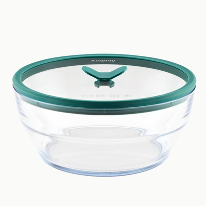 A 12-cup Glass Round Deep Dish by Anyday, featuring a kale-green rimmed transparent silicone lid with a central triangular vent, sits empty against a plain white background—perfect for meal-prepping or making batch soups.