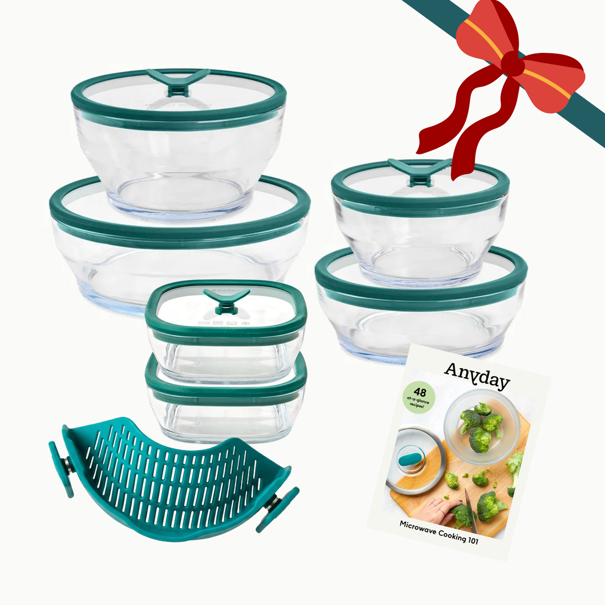 A Steph’s Must-Haves (kale) set of glass bowls with glass lids, a slotted silicone insert, and a recipe booklet tied with a red ribbon.